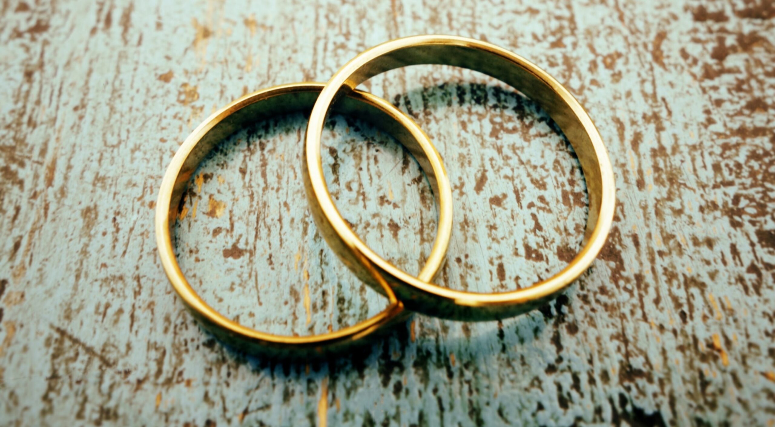 A pair of gold rings on a stone surface