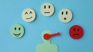 a group of paper people with different emotions on a blue background.